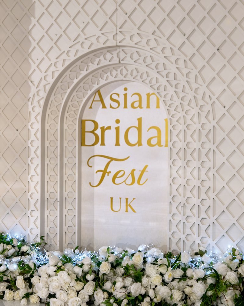 The Asian Bridal Fest UK fretwork arch backdrop dressed with a bank of white roses